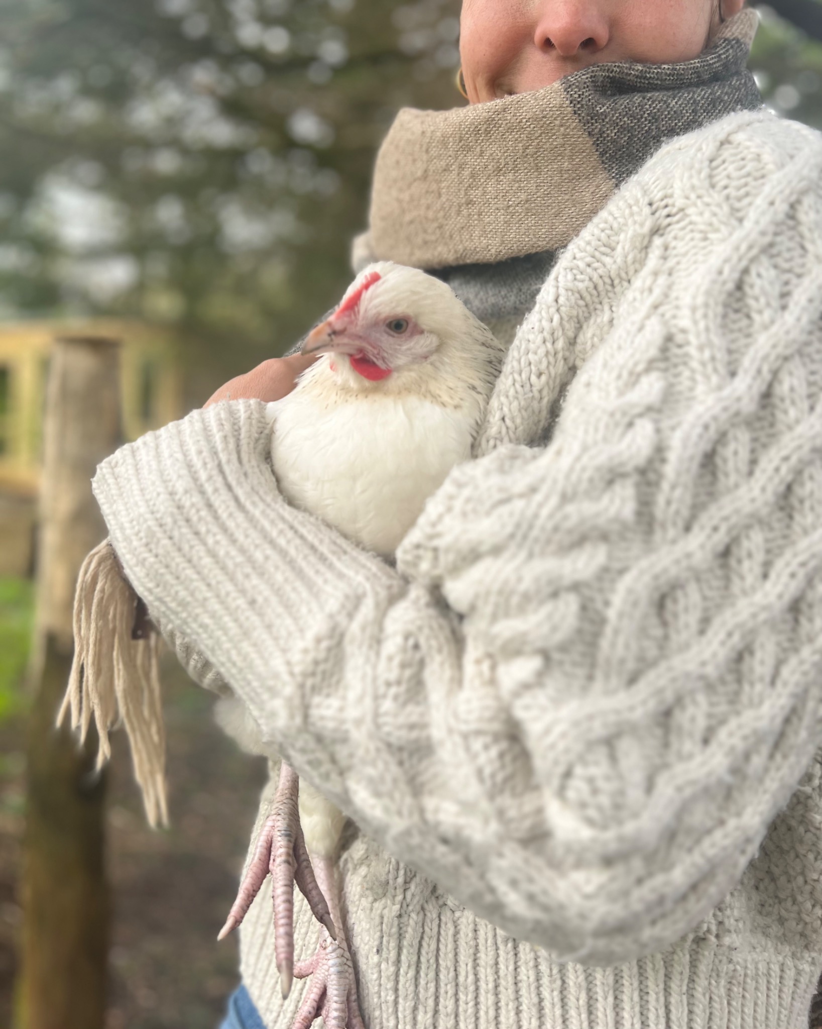 Izzy holding a white hen on the smallholding